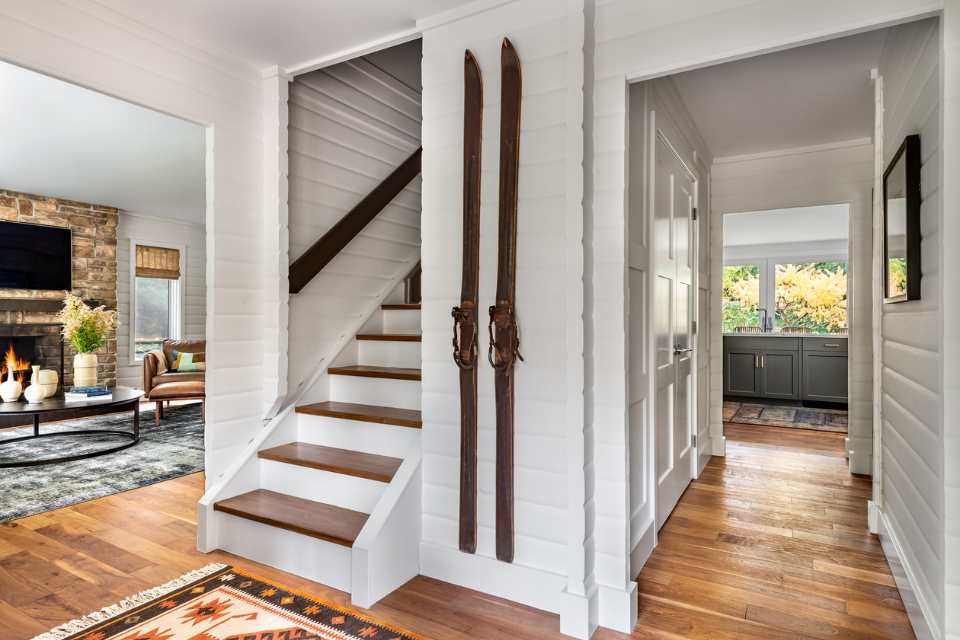 entryway of rustic cottage with old wooden ski decor near staircase